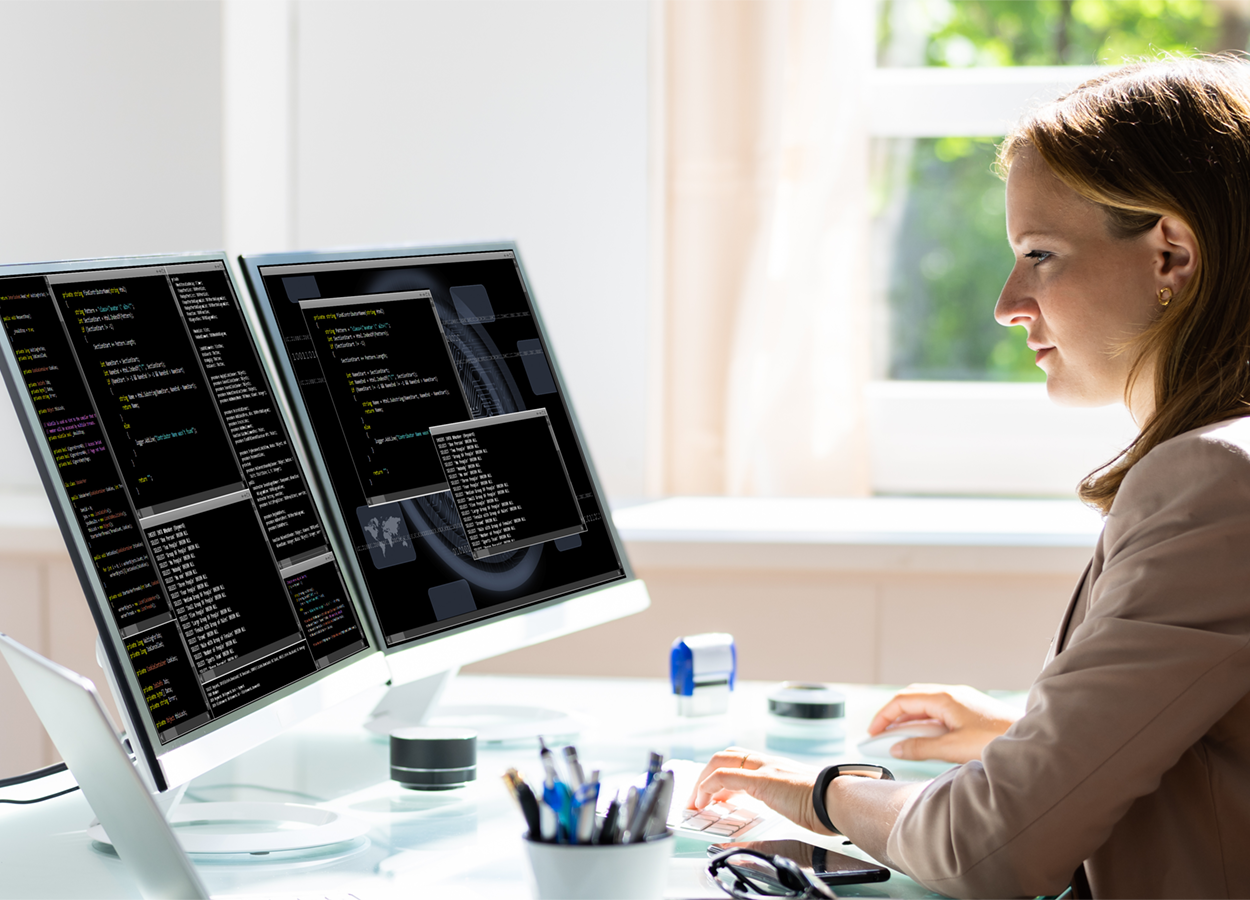 A programmer writing code on their laptop.