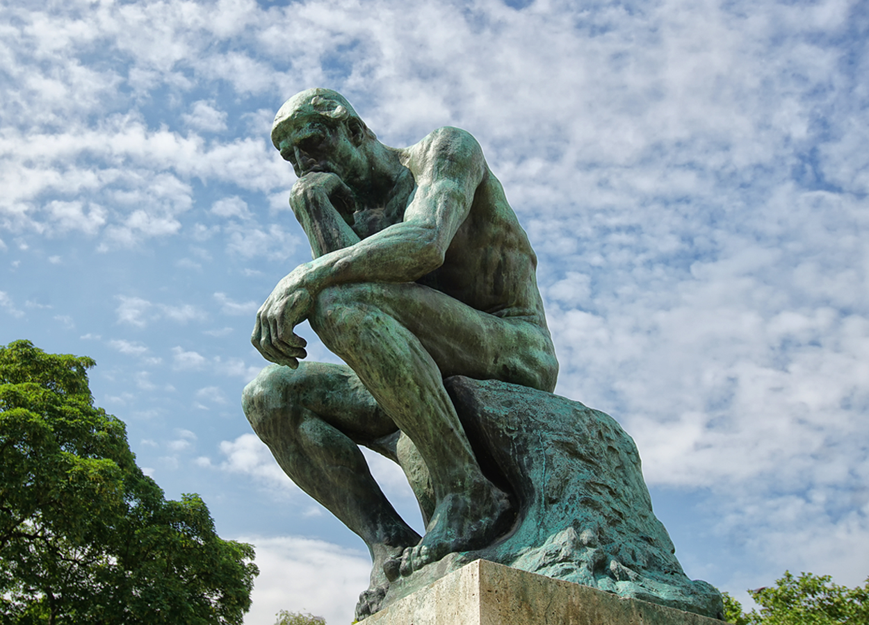 Image of Rodin's Thinker stature, showing a man deep in thought