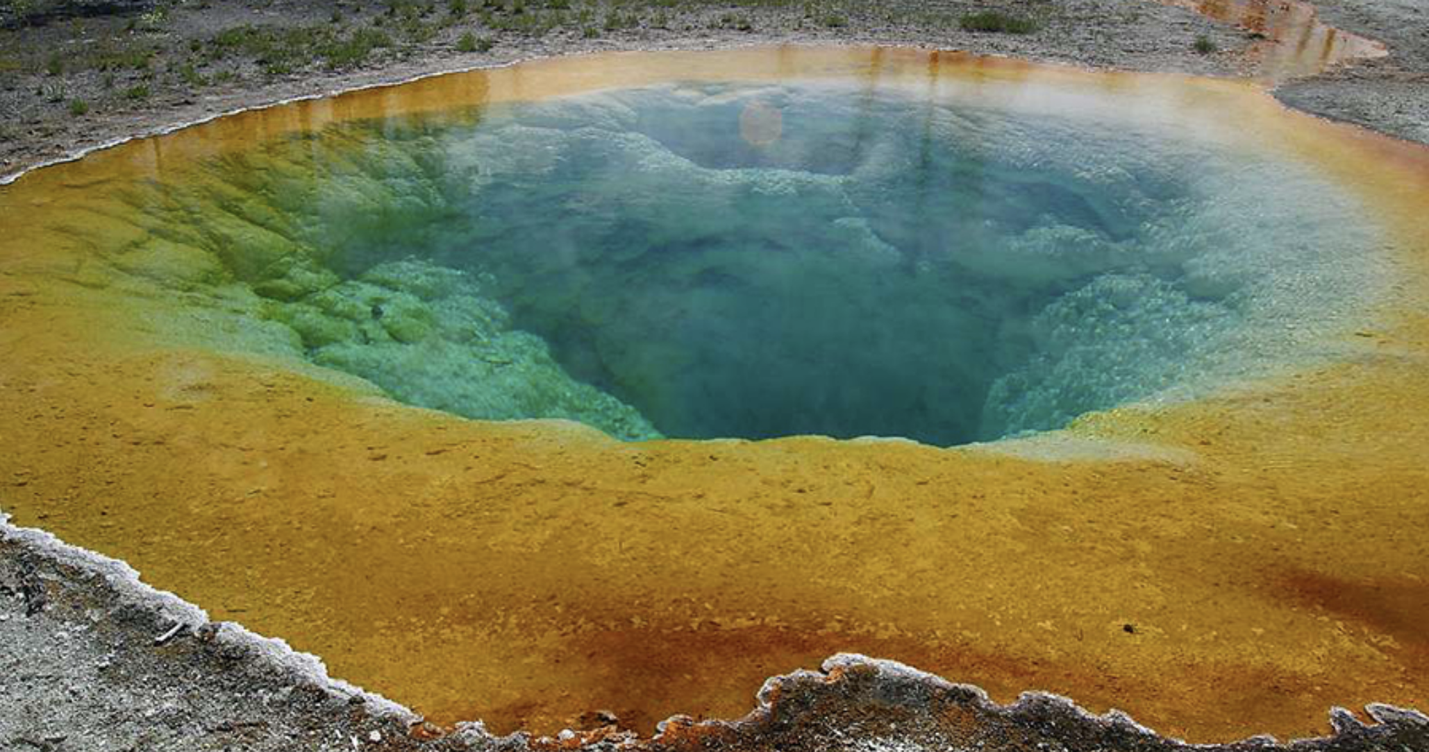 A photograph of a pool of water that changes in color from orange on the edges to blue in the center.