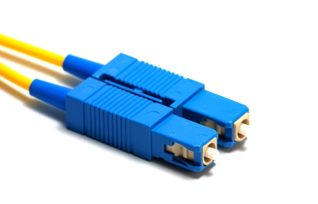 Two fiber-optic cables with S C connectors. The cables appear as slender wires, whereas the connectors are characterized by their rectangular shape and feature a plastic tip at the end.