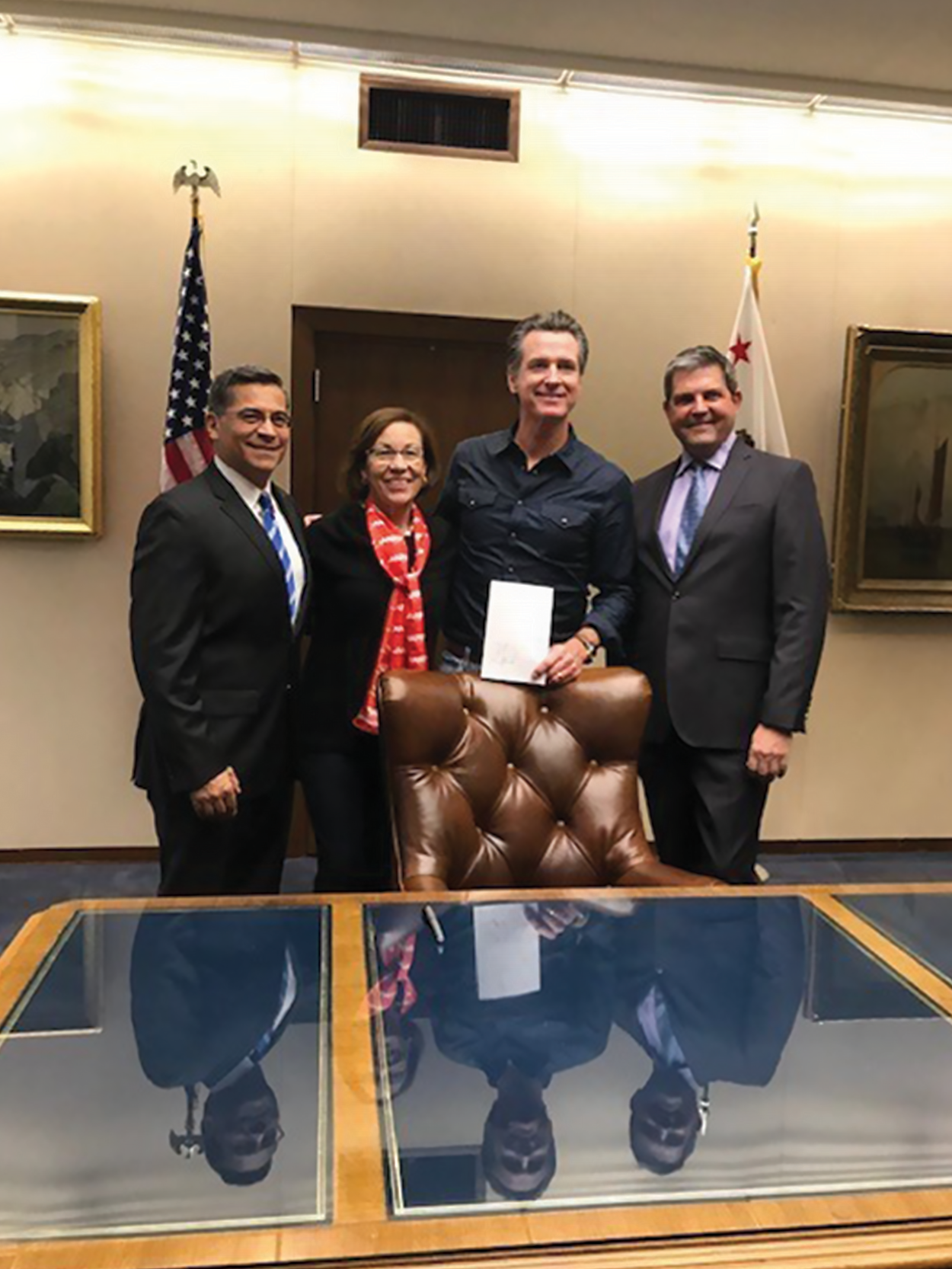 Three people posing with Governor Newsom for a photo.