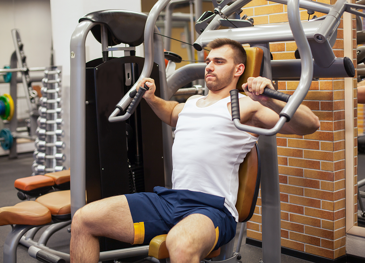 Performing a chest press on a weight machine.