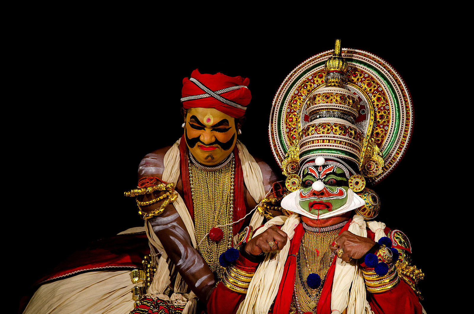men in brightly painted makeup and elaborate headdresses