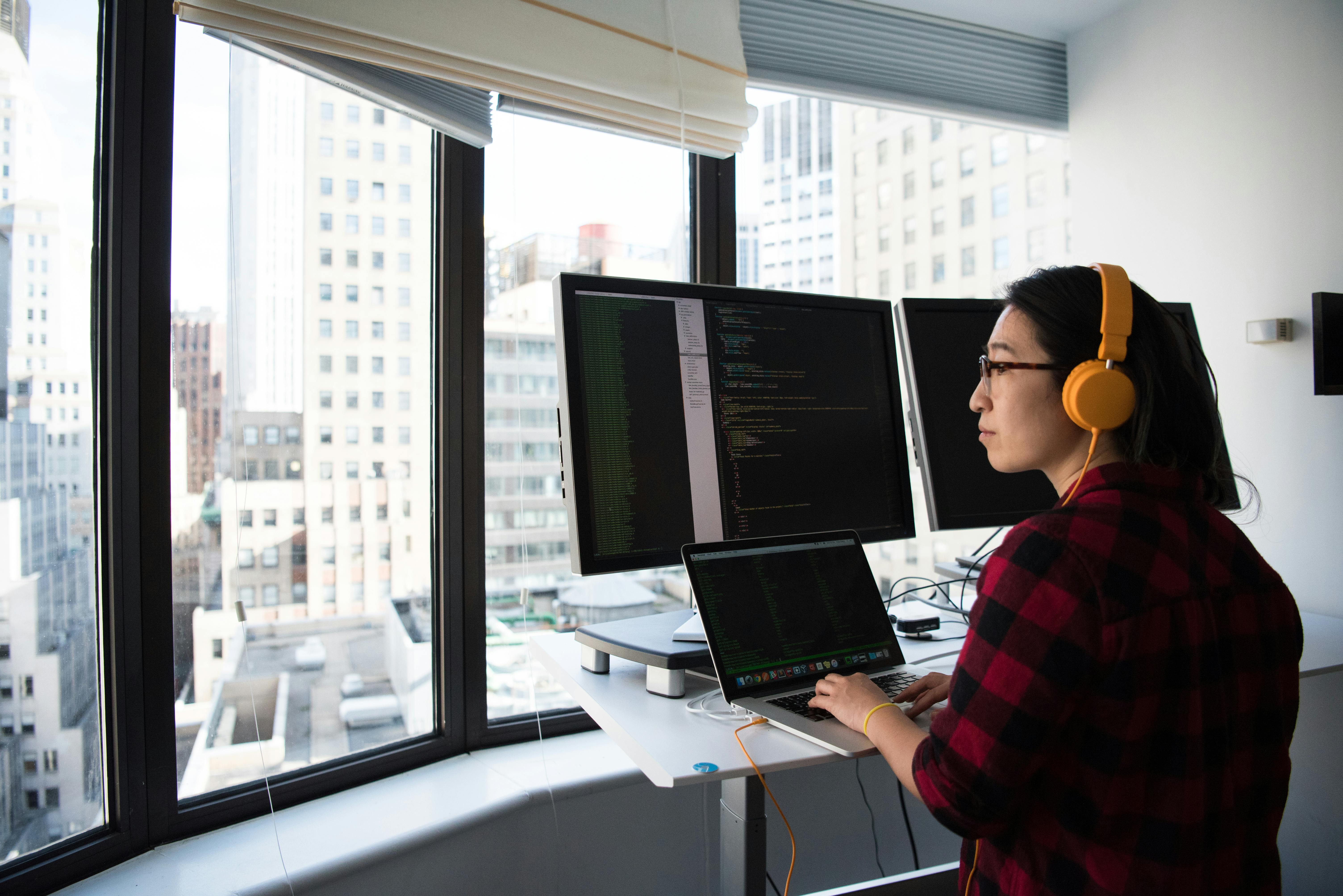 a young woman working on a computer in a high-rise office building
