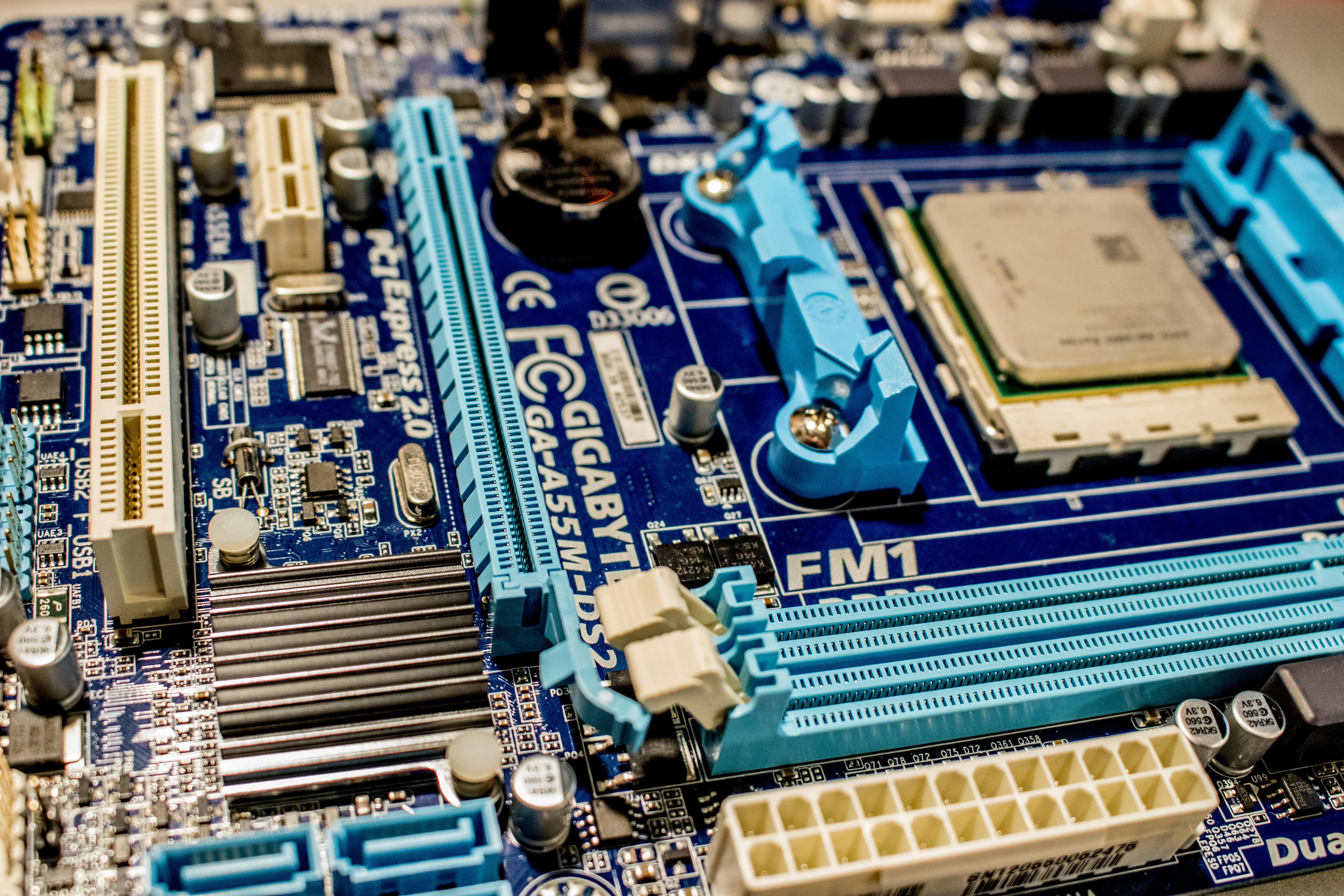 A Gigabyte GA-A55M-DS2 motherboard consisting of various components such as a C P U, DIMM or RAM slots, capacitors, integrated chips, and a C MOS battery.