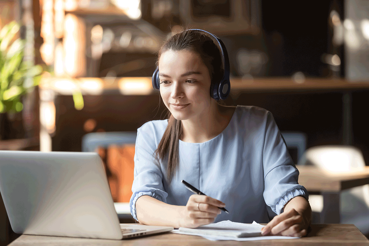 A young woman wearing headphones participates in a remote usability test using a laptop computer.
